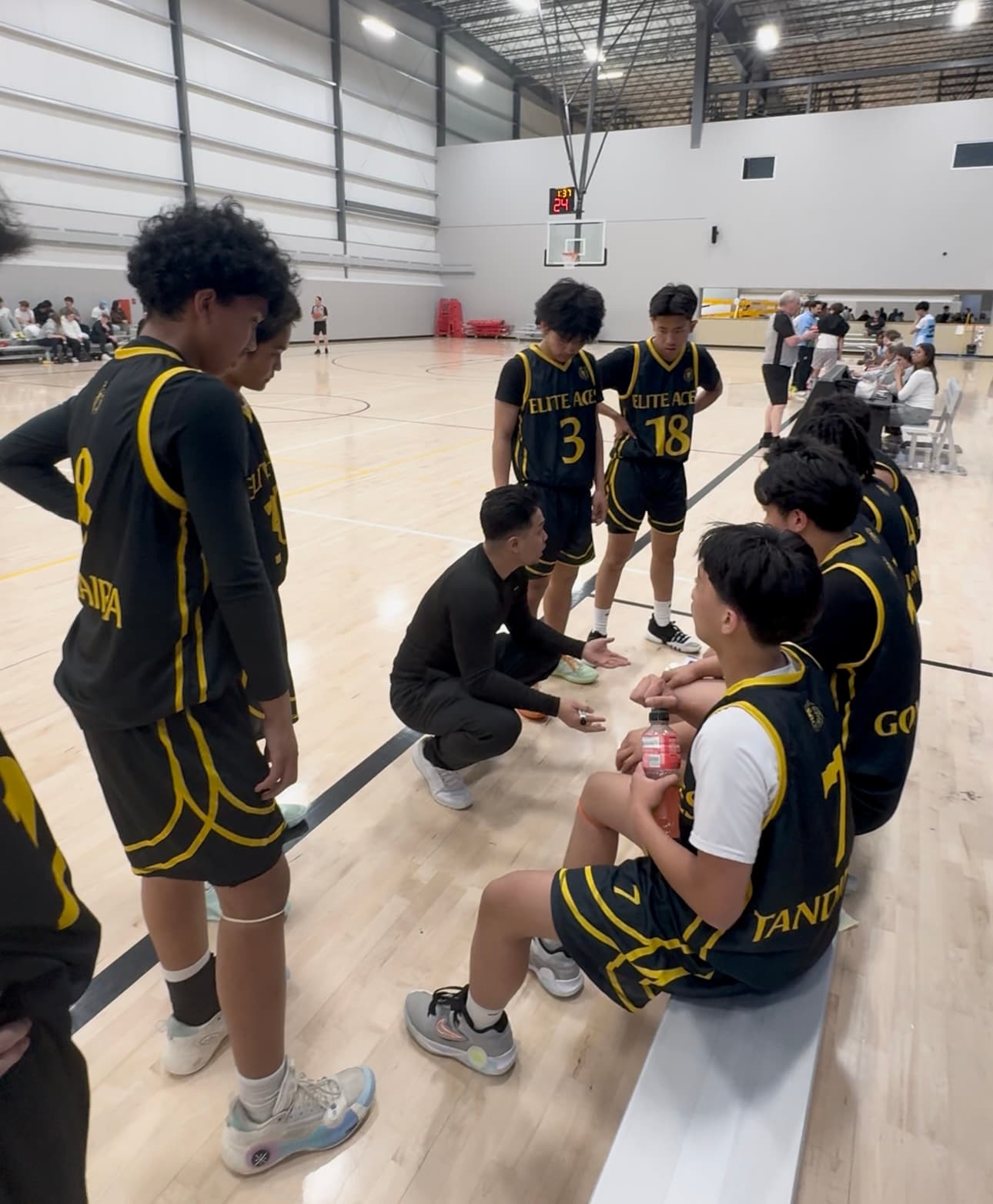 A photo of Coach Ian motivating the Elite Aces High School Division Team during a timeout.